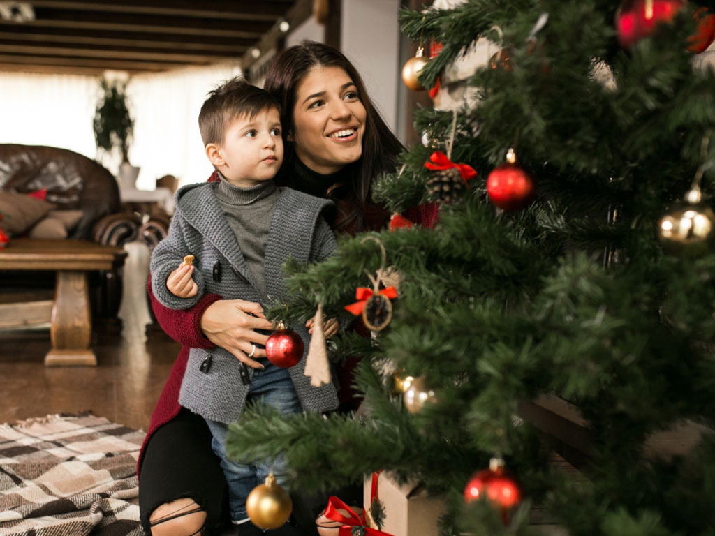 a mother and son putting up the christmas tree