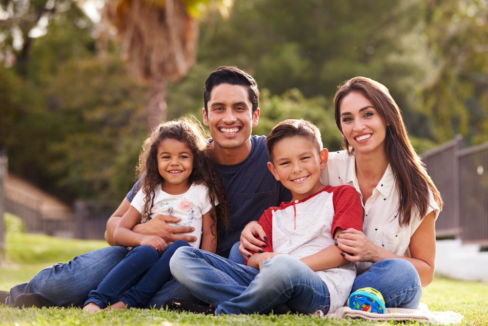 A family smiling and sitting in the park